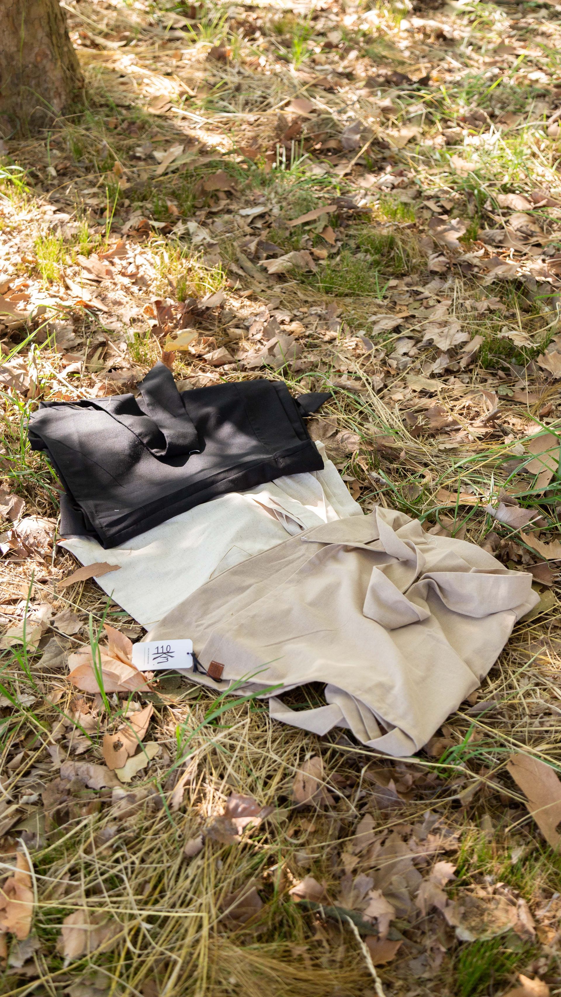 Mujer con camiseta blanca y falda, al aire libre frente a un área verde.