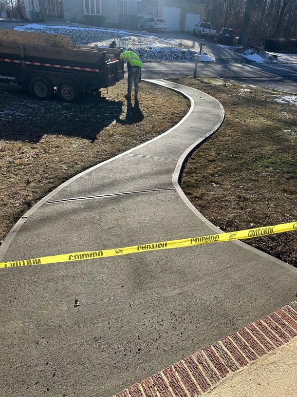A man is working on a concrete walkway.