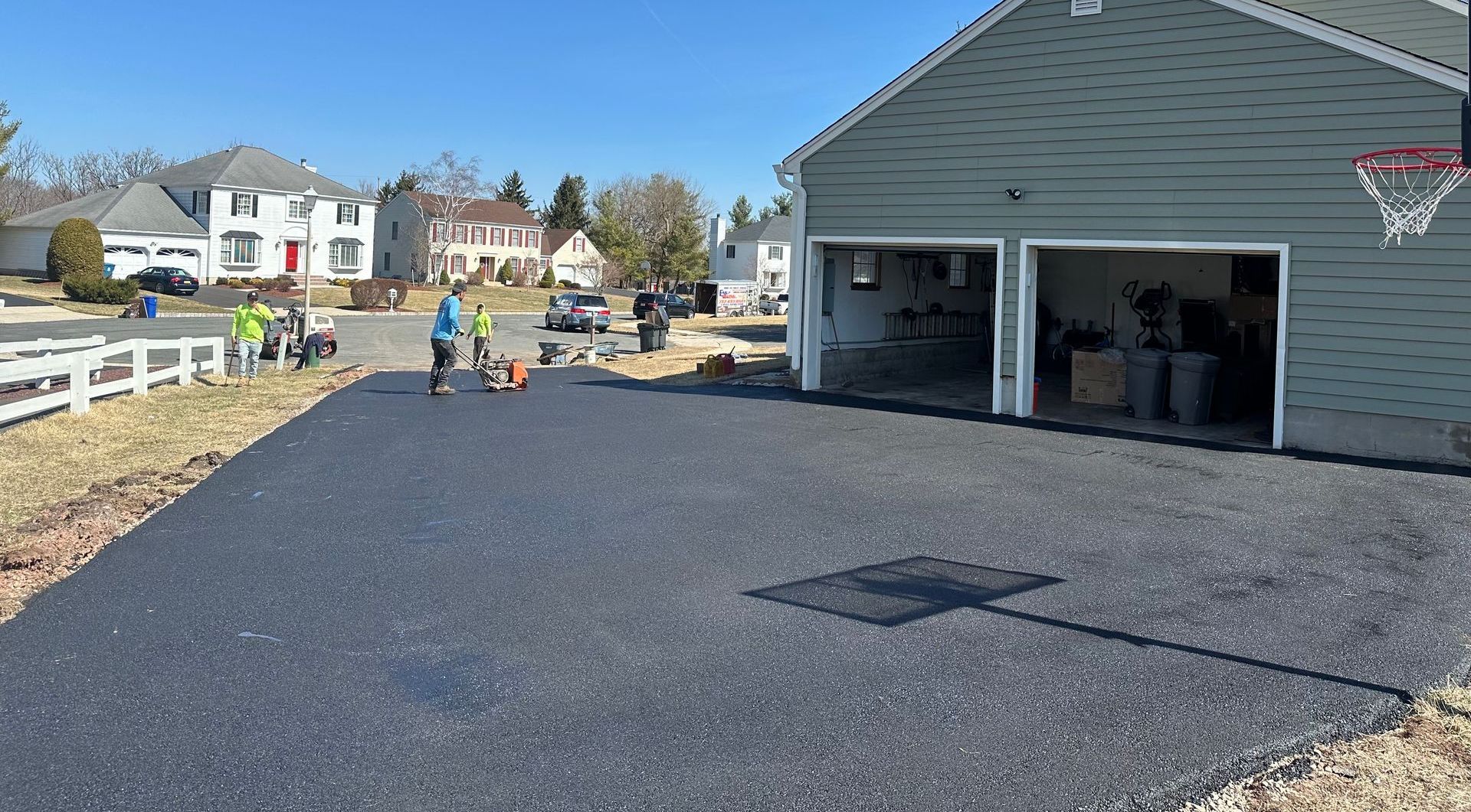 A basketball hoop is hanging on the side of a garage.
