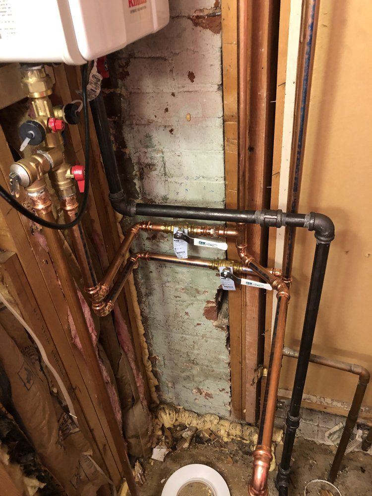 copper pipes are connected to a water heater in a bathroom