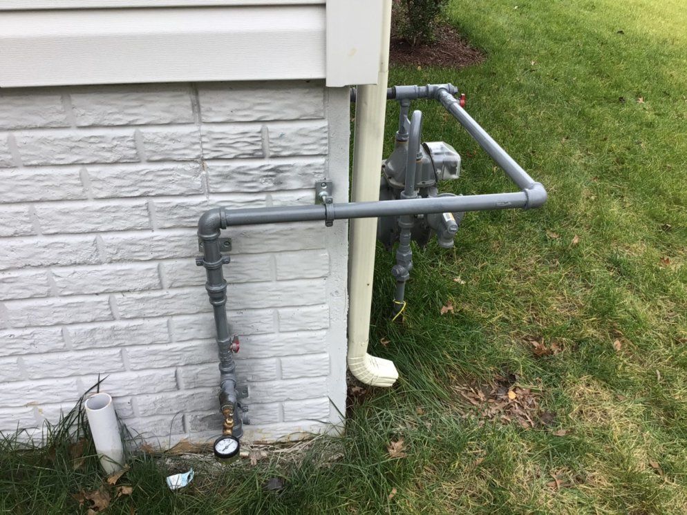 a pipe is attached to the side of a brick building .