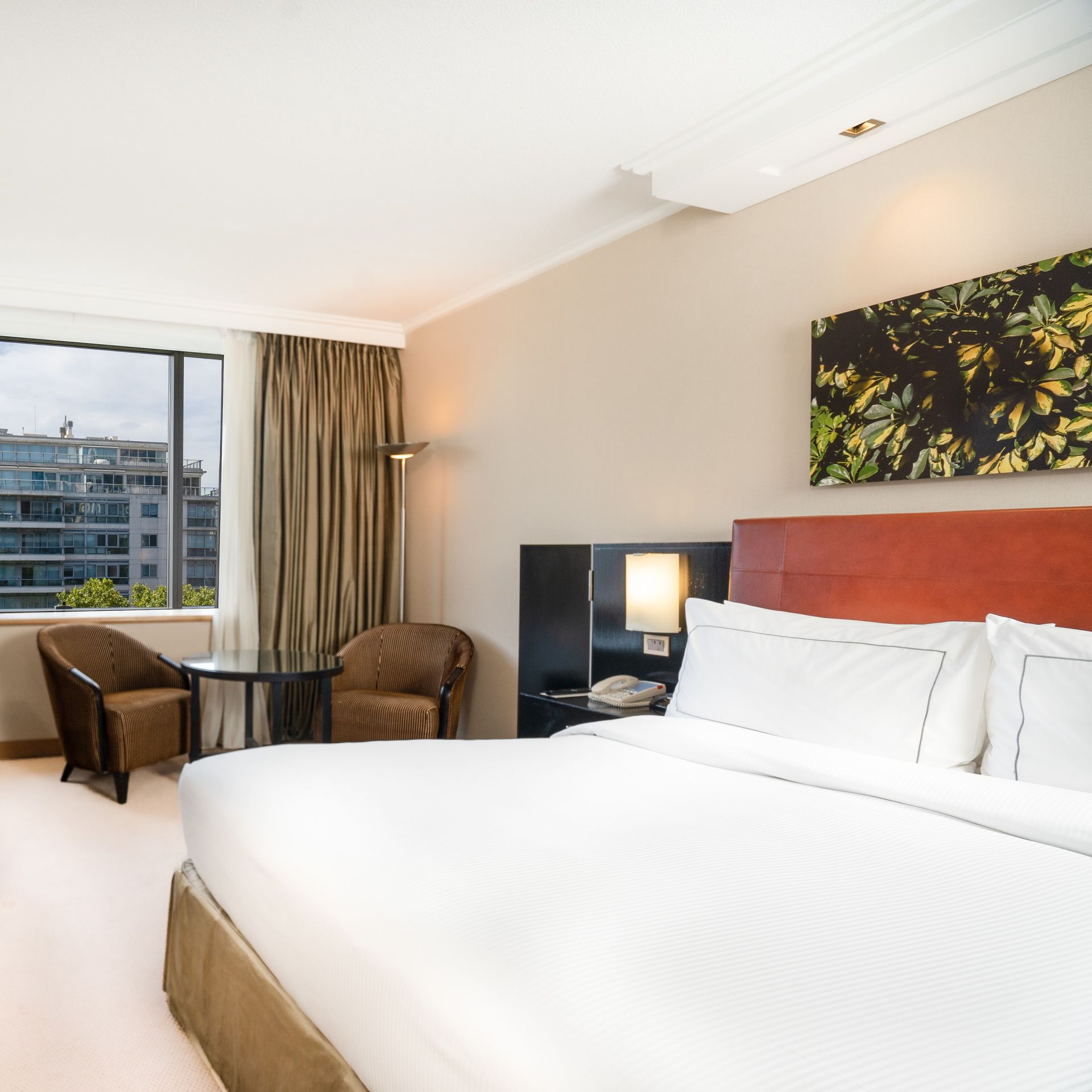 Una habitación de hotel con una cama grande y sillas.