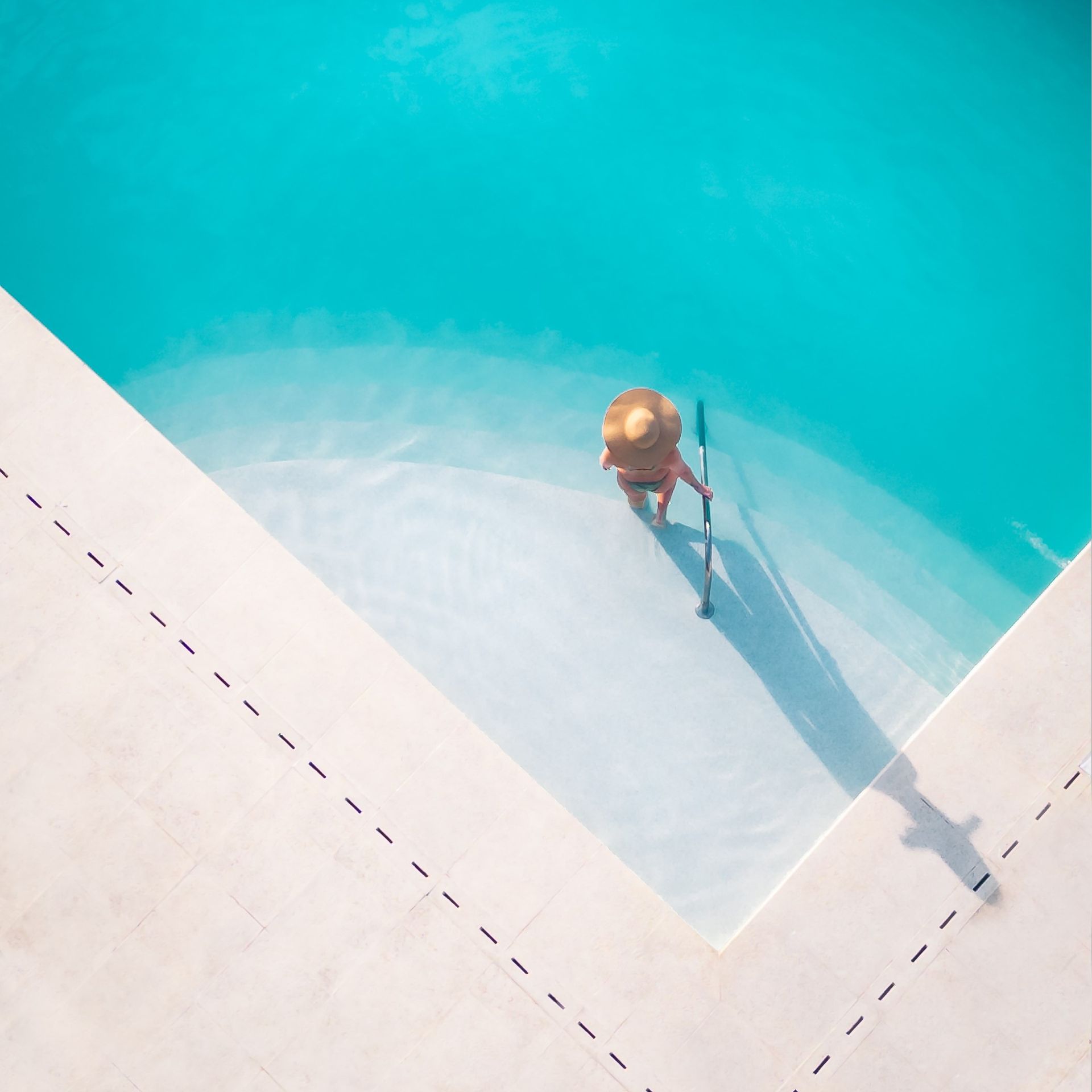Una vista aérea de una persona parada junto a una piscina.