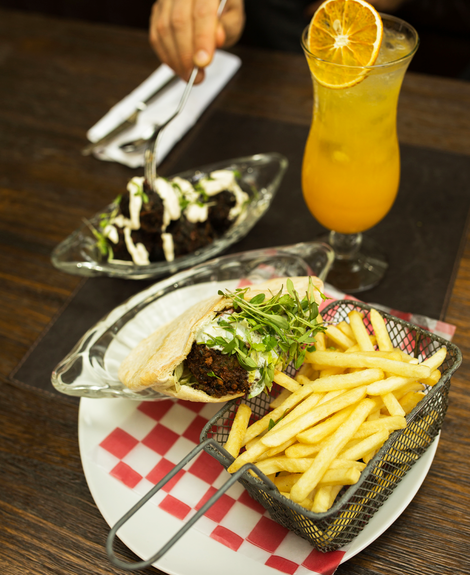 Un plato de comida con patatas fritas y una bebida sobre una mesa.