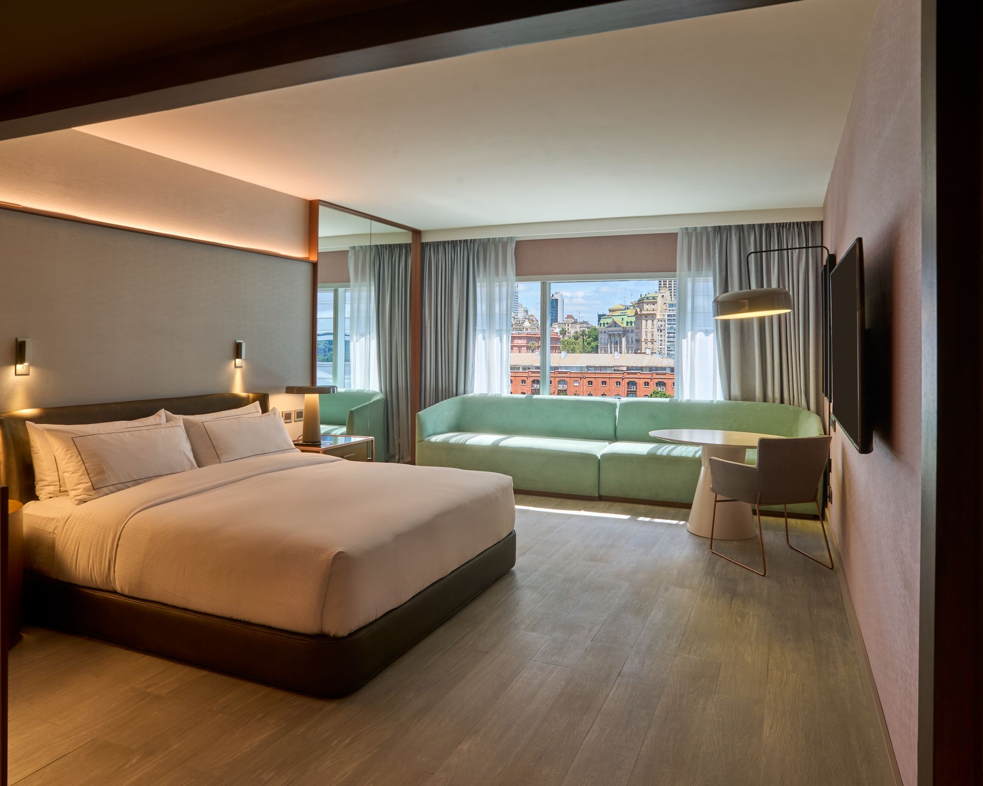 Una habitación de hotel con una cama king size y un sofá verde.