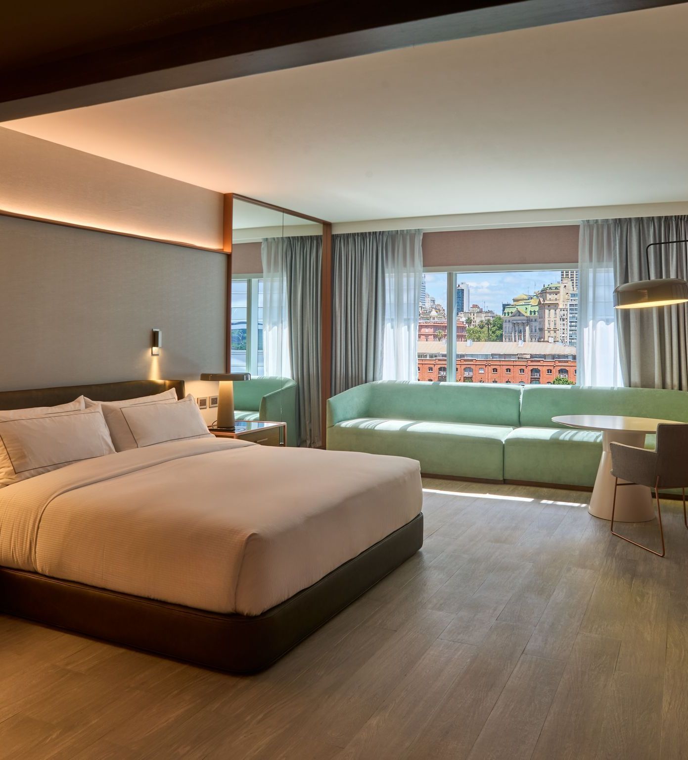 Una habitación de hotel con una cama grande y un sofá verde.