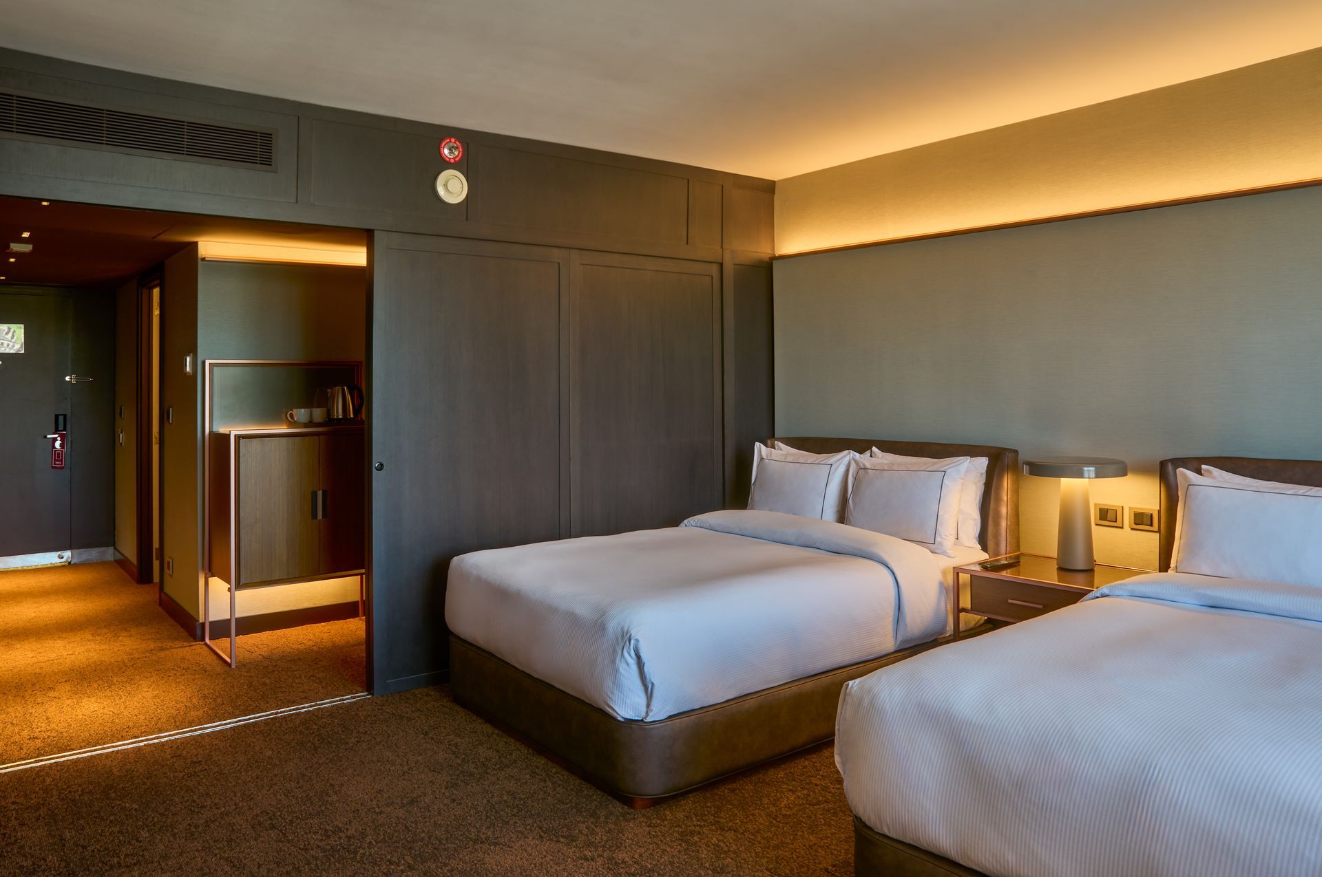 Una habitación de hotel con dos camas y un baño.
