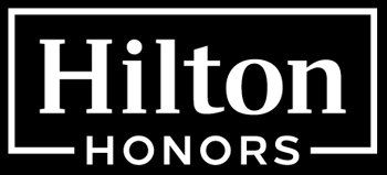 El logotipo de Hilton Honors es blanco sobre fondo negro.