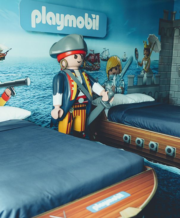 Un dormitorio con un cartel de playmobil en la pared.