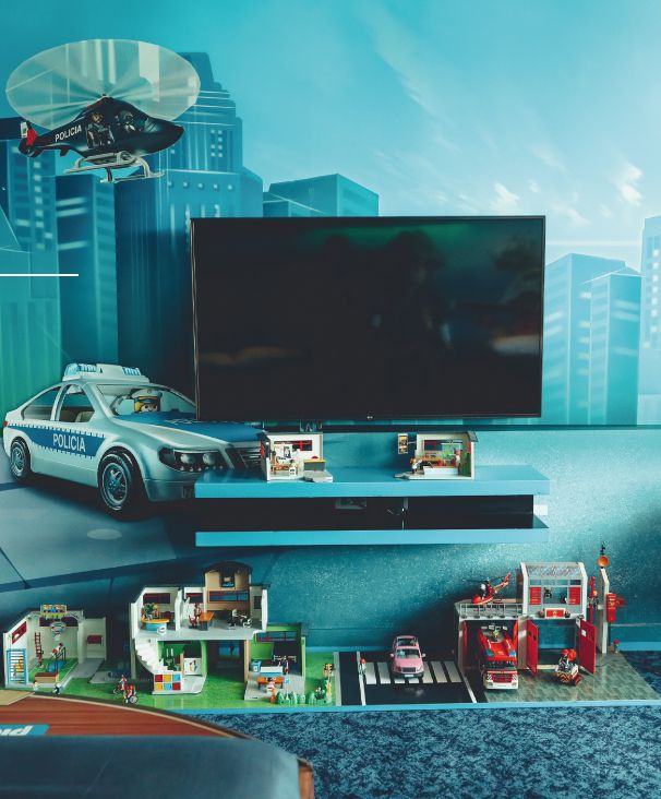Hay un coche de policía en la pared detrás de un televisor de pantalla plana.