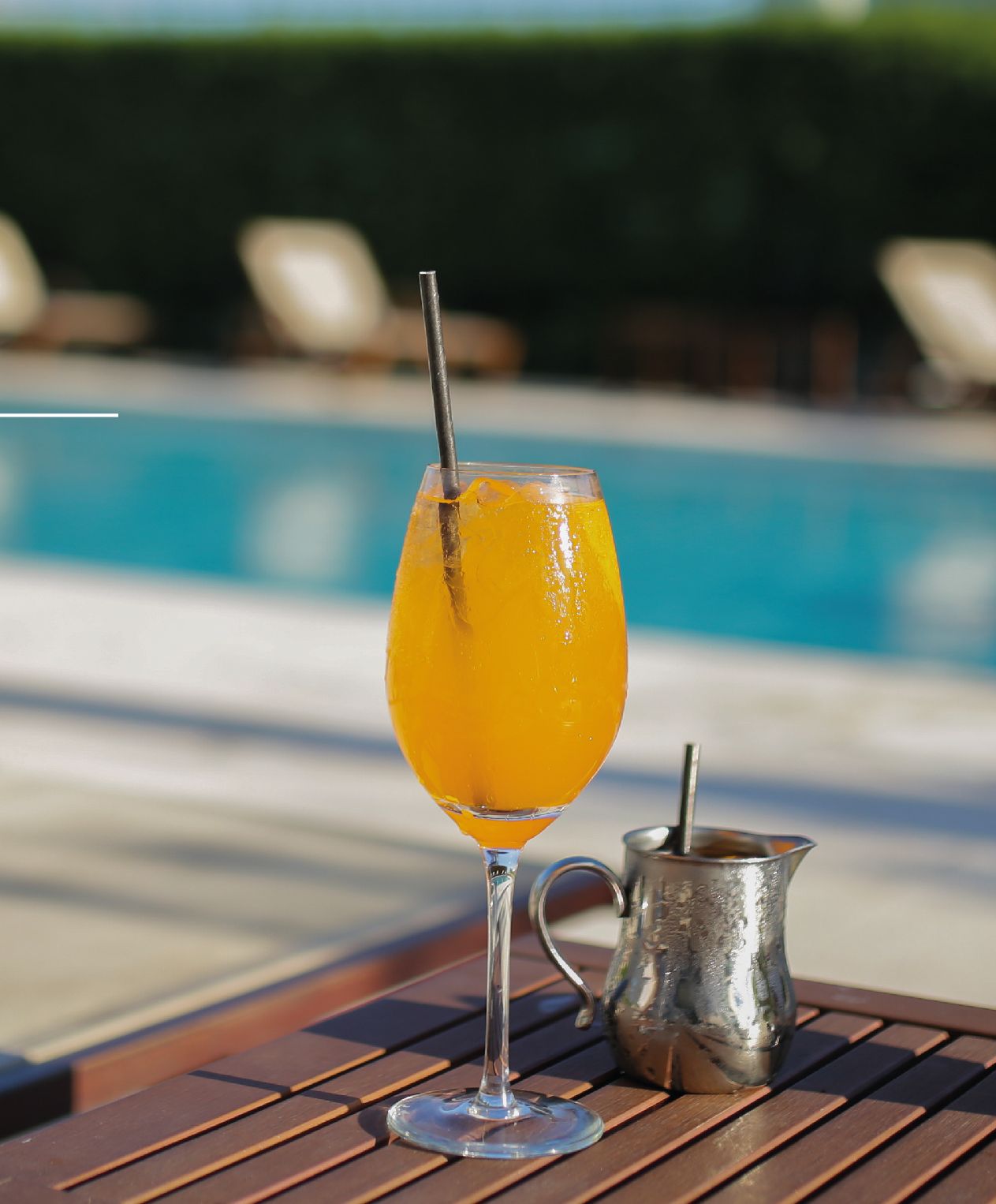 Un vaso de jugo de naranja con una pajita sobre una mesa