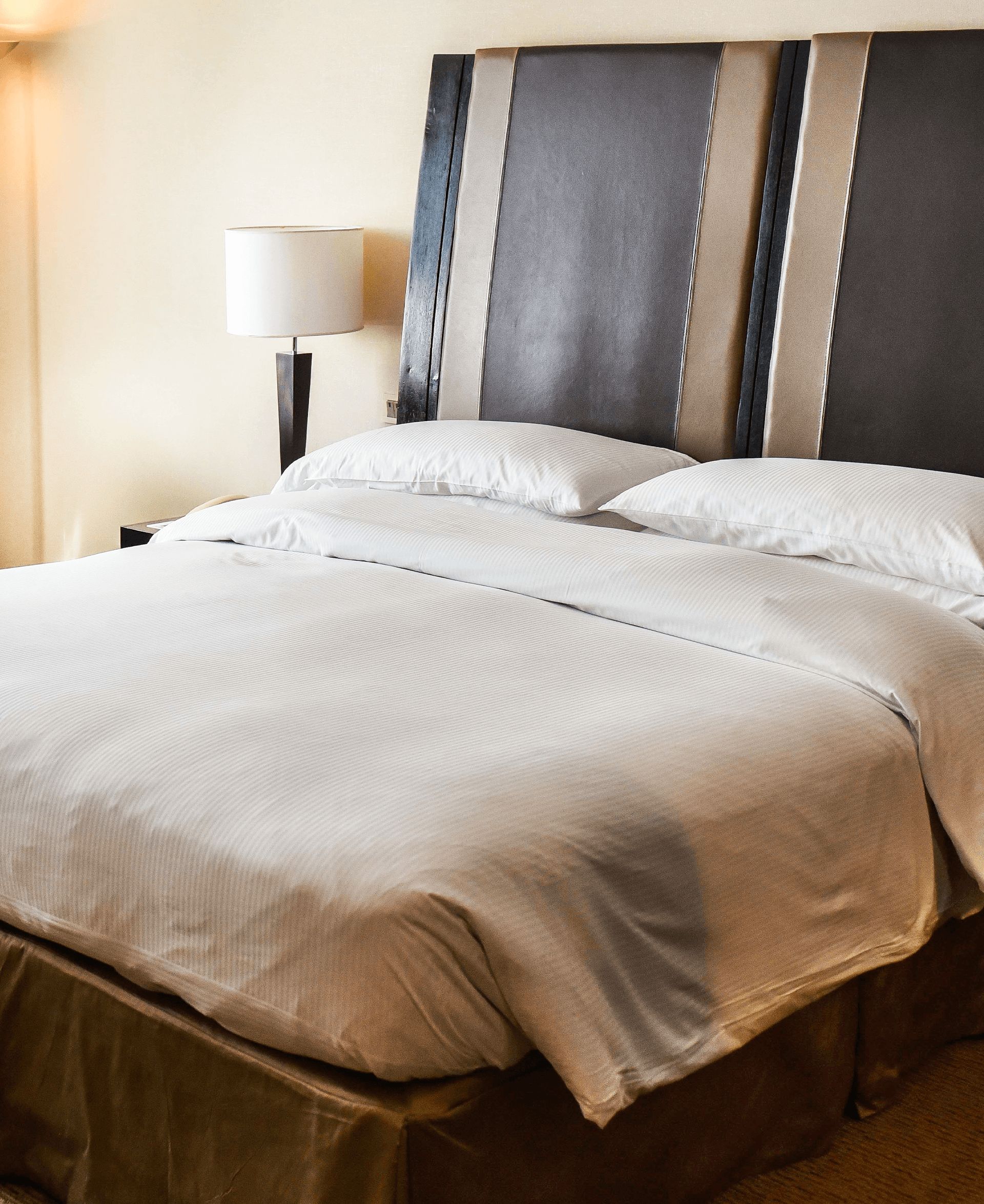 Una habitación de hotel con una cama grande y una lámpara.