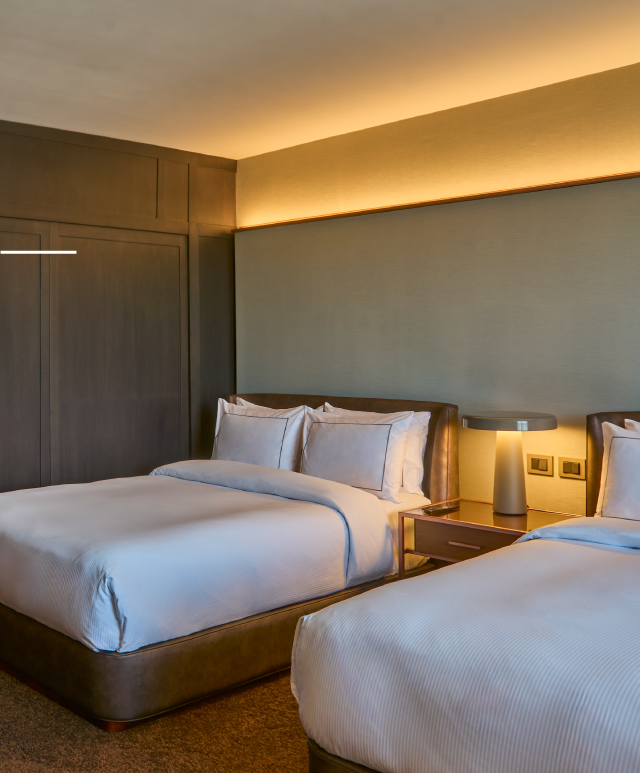 Una habitación de hotel con dos camas y dos lámparas.