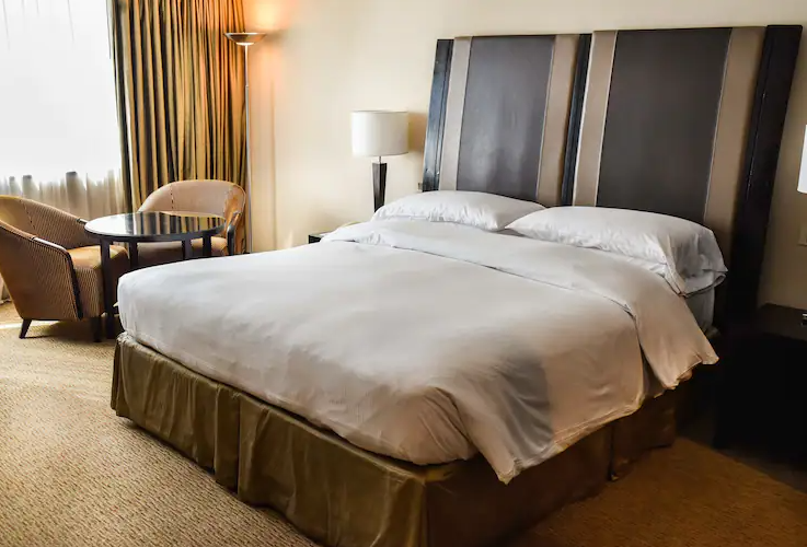 Una habitación de hotel con una cama king size y sillas.