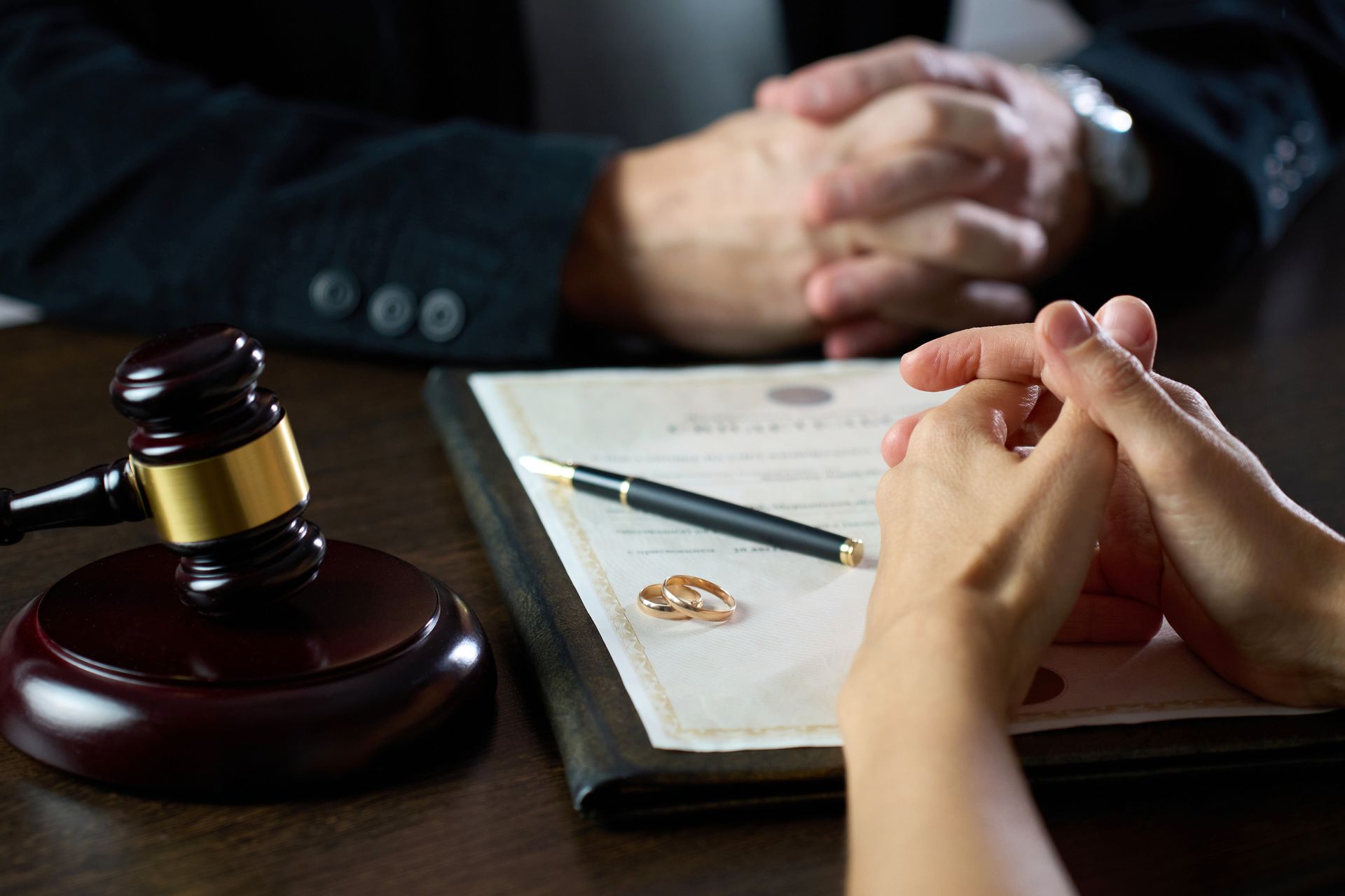 A man and a woman are sitting at a table with a judge 's gavel.