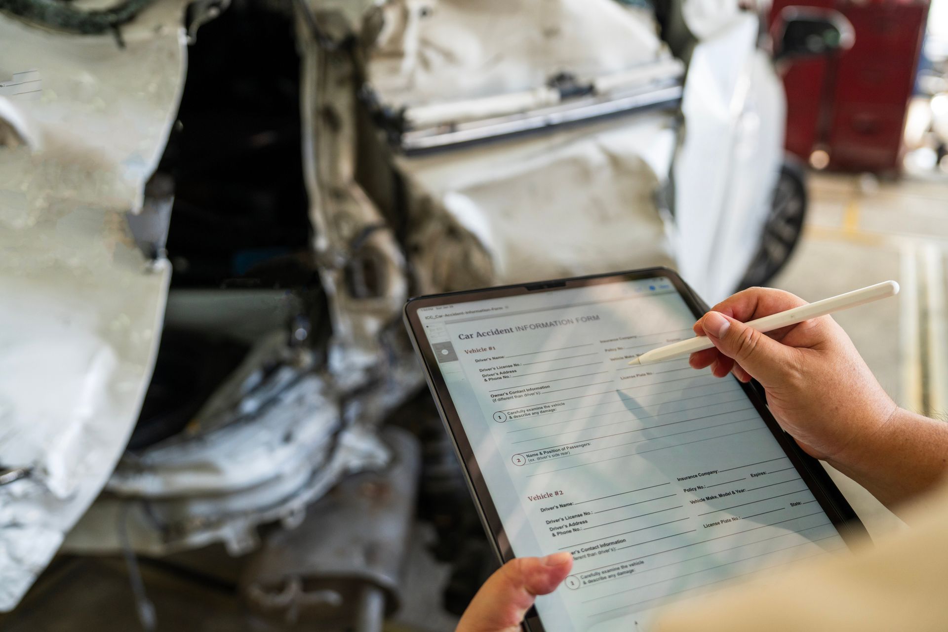 A person is using a tablet with a pen in front of a tank.