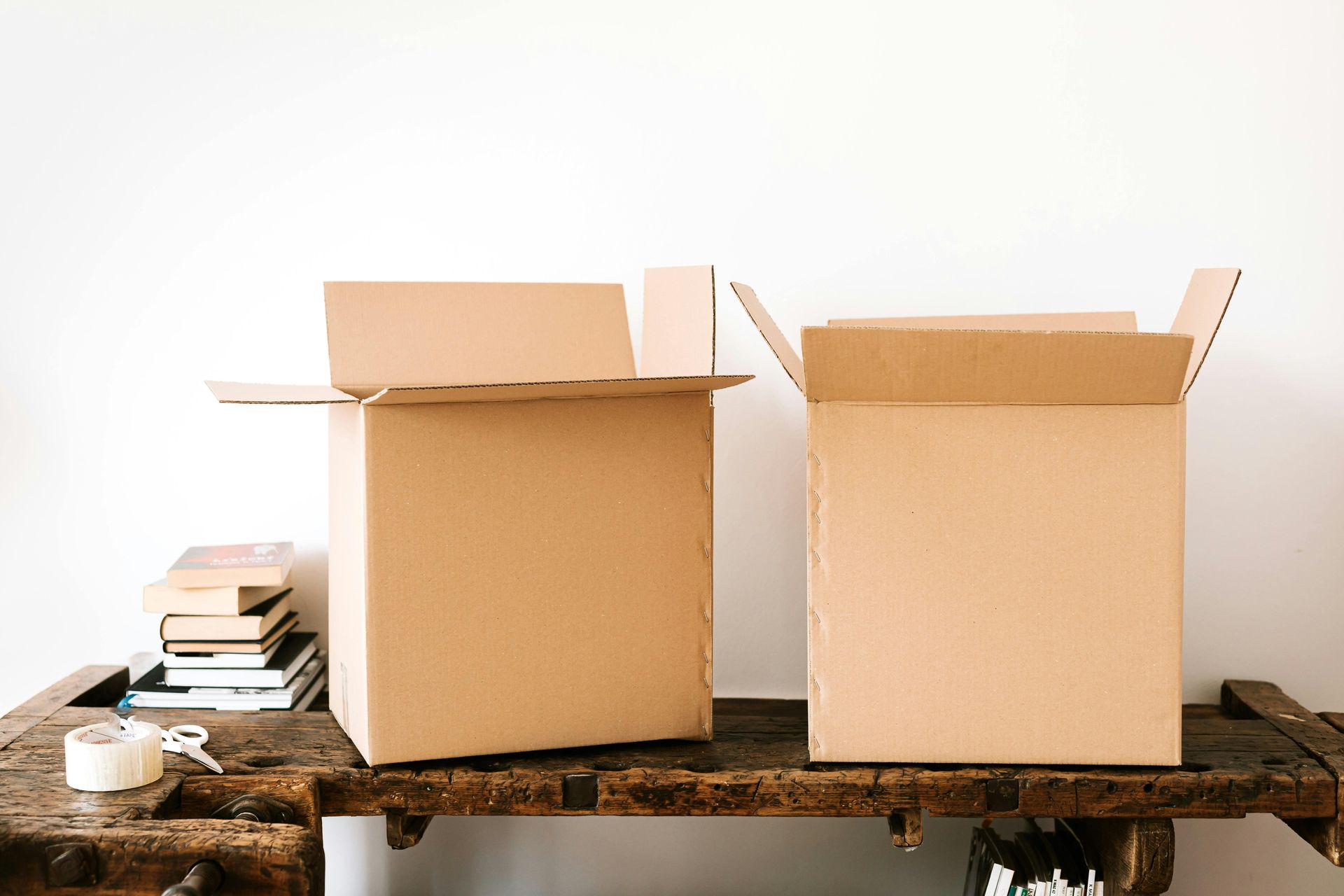 A stack of cardboard boxes in a kitchen including one that says ' vibes ' on it