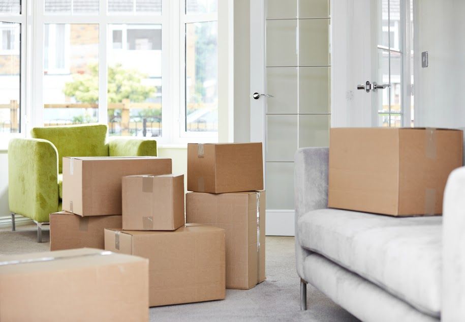 A stack of cardboard boxes in a kitchen including one that says ' vibes ' on it