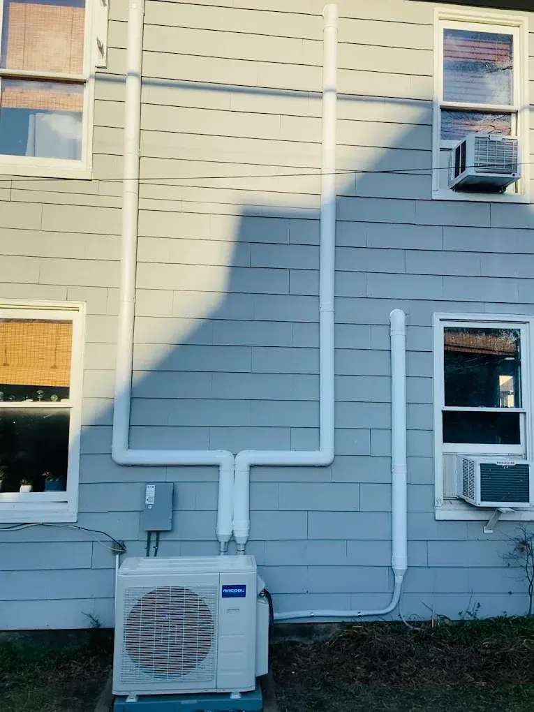 A hand holds a clear glass under a chrome kitchen faucet as water pours into the glass.