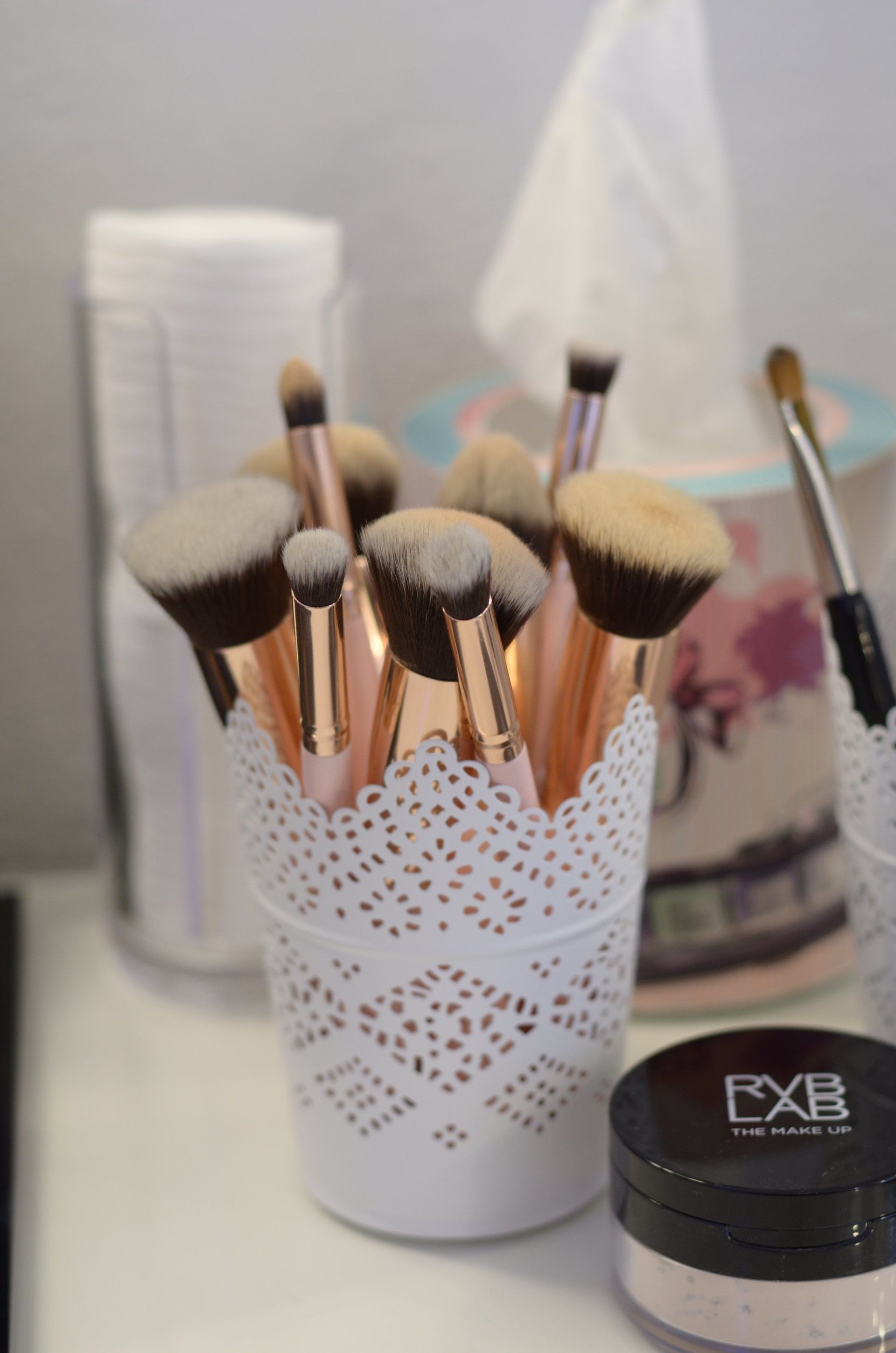 Ein Bündel Make-up-Pinsel in einem weißen Spitzenbehälter