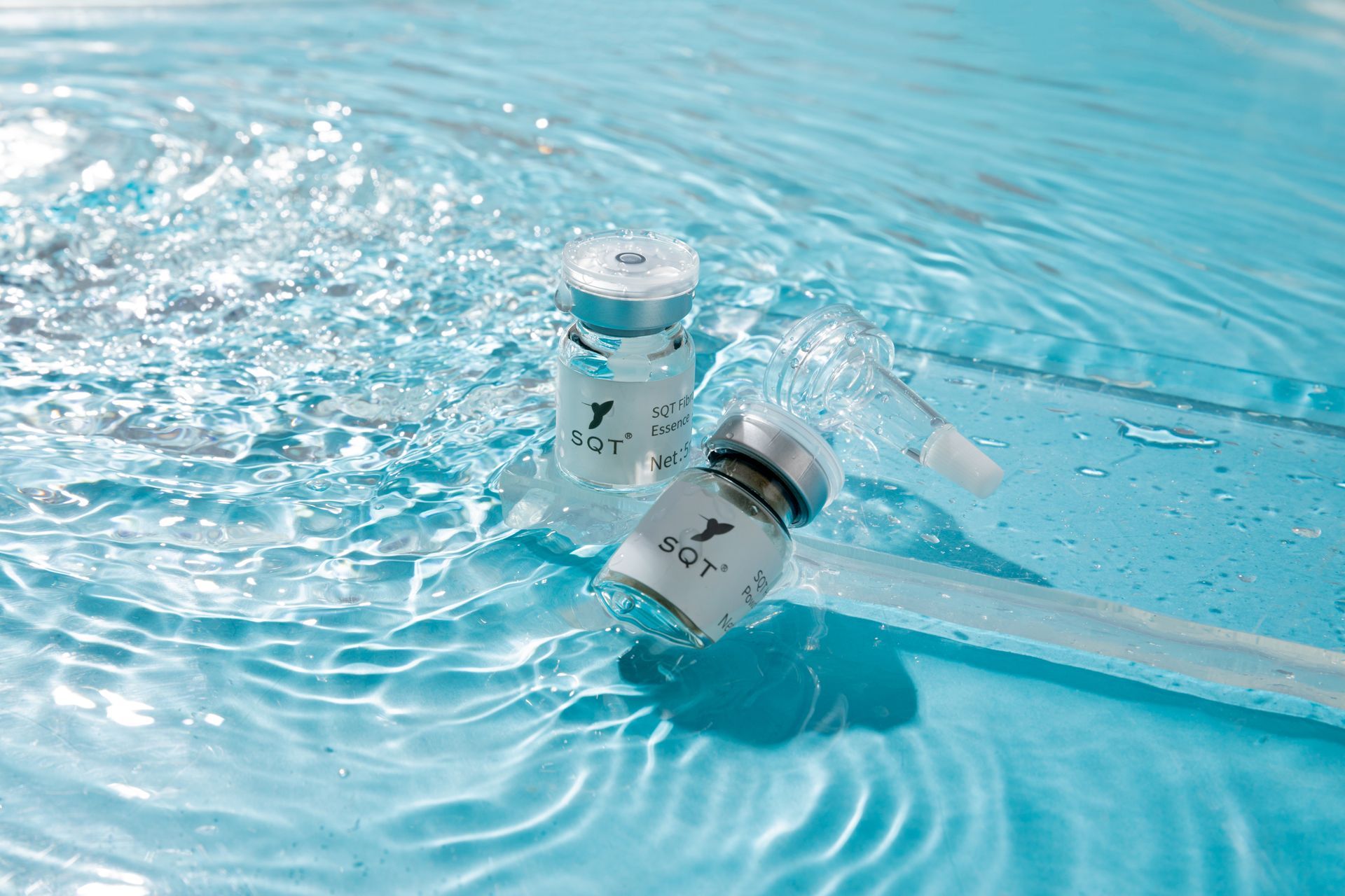 Zwei Kosmetikflaschen schwimmen im Wasser.