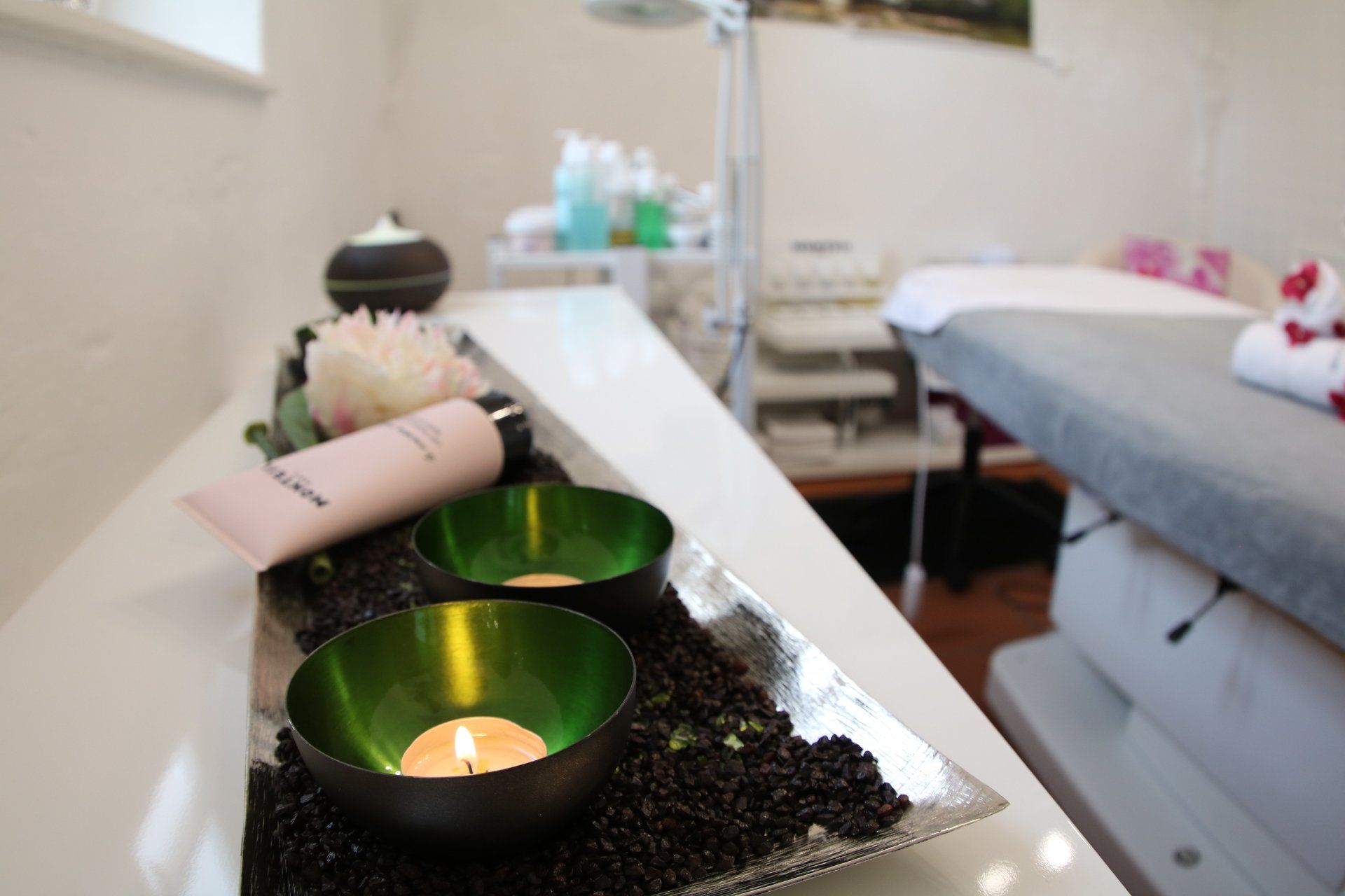 Ein Tisch in einem Spa mit Kerzen und Lotion darauf