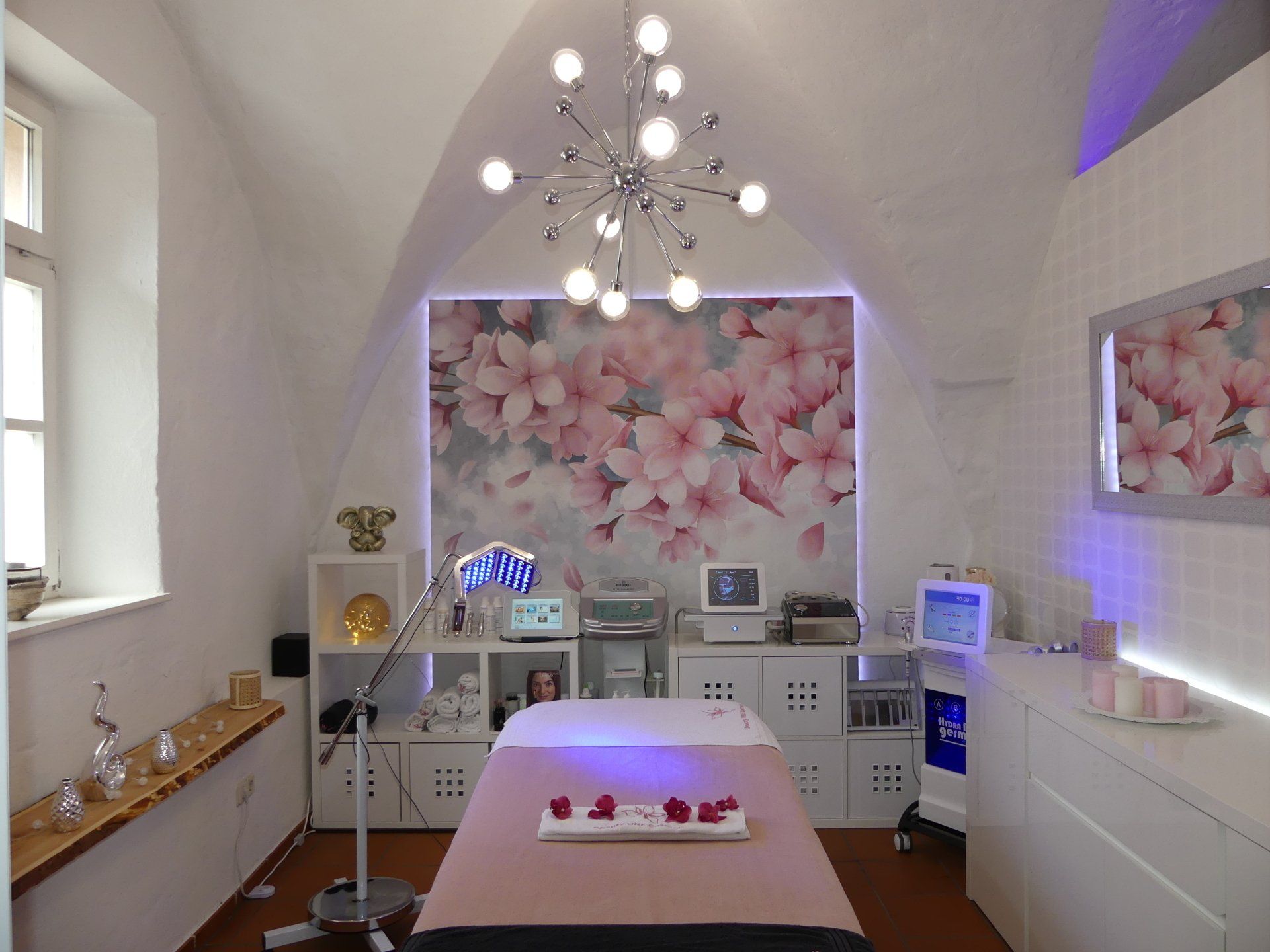 Ein Zimmer mit einem Bett und einer Wand mit Blumen daran