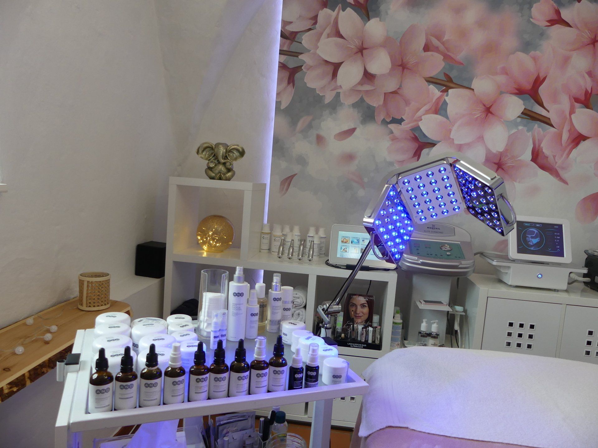 Ein Raum mit einem Tisch voller Flaschen und einer Wand mit rosa Blumen.