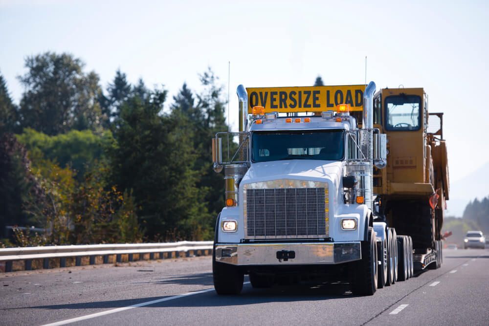An Oversize Load Truck is Driving Down a Highway — ASAP Towing Pty Ltd in Bells Bridge, QLD