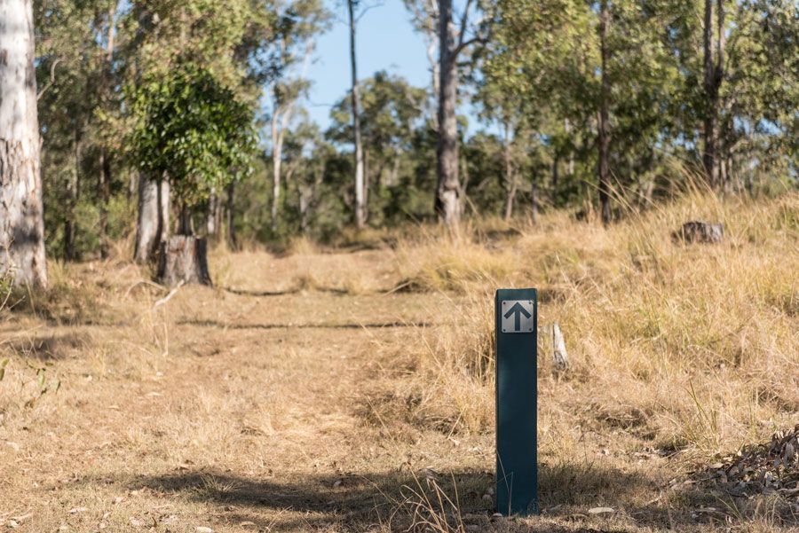 A Blue Pole With an Arrow Pointing to the Right in a Field With Trees in the Background — ASAP Towing Pty Ltd in Amamoor, QLD