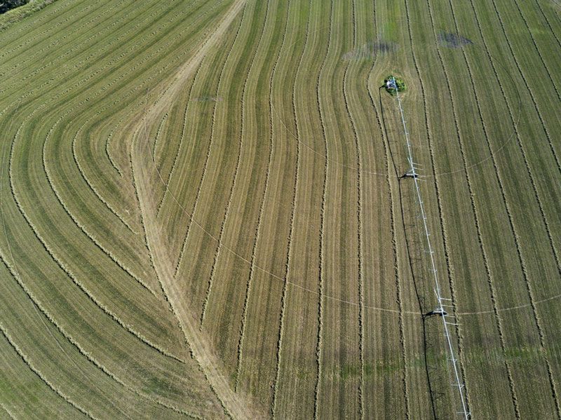 An Aerial View of a Tractor Plowing a Field of Grass — ASAP Towing Pty Ltd in Goomeri, QLD