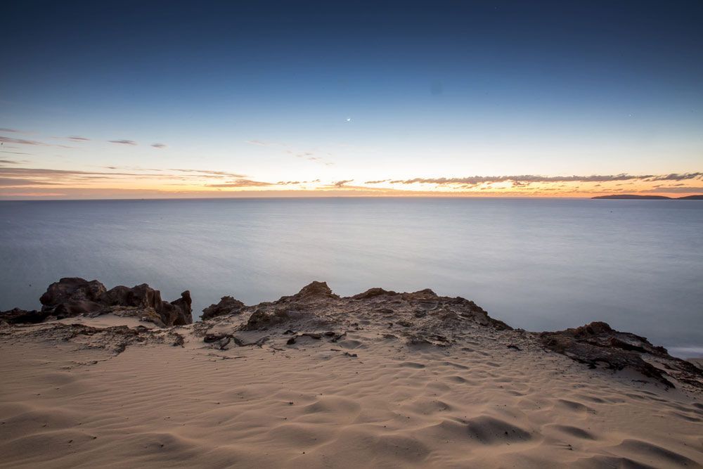 A Sunset Over the Ocean With a Sandy Beach in the Foreground — ASAP Towing Pty Ltd in Rainbow Beach, QLD