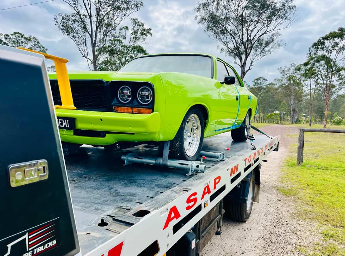 A Green Car is Sitting on Top of a Tow Truck — ASAP Towing Pty Ltd in Urangan, QLD