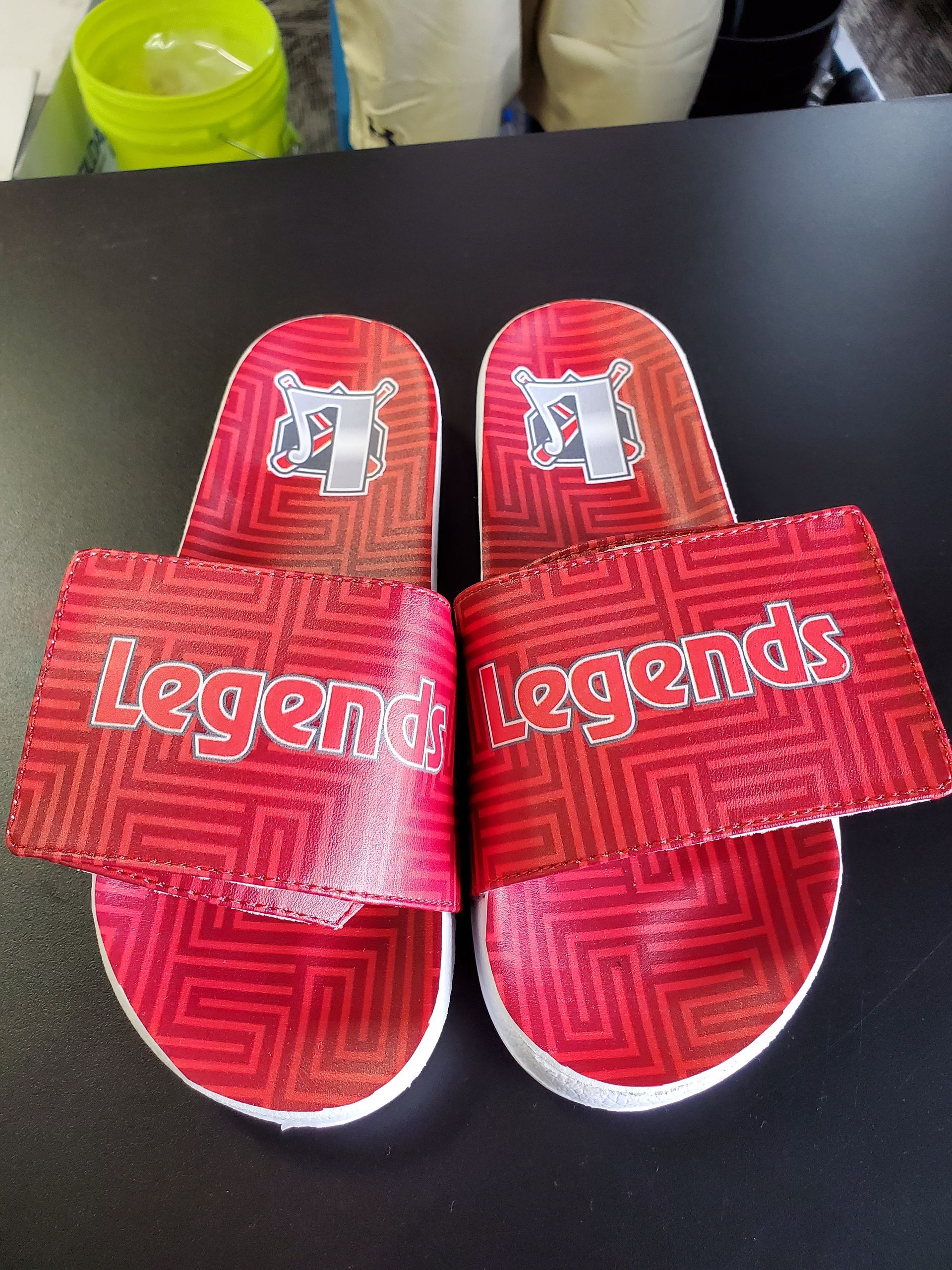 Red Legends slide sandals with white soles and team logo.