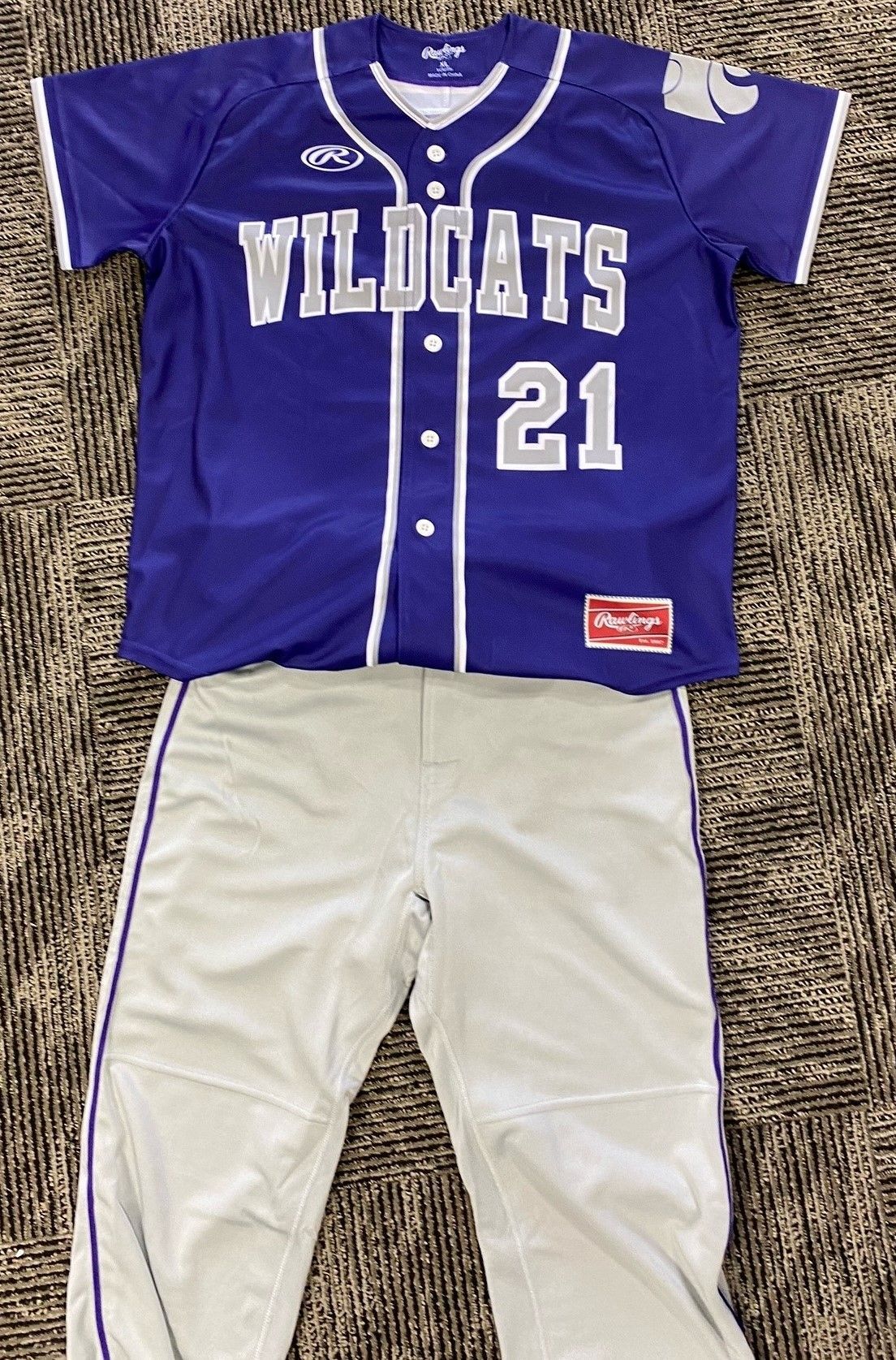 Purple Wildcats baseball jersey with number 21, and gray baseball pants.