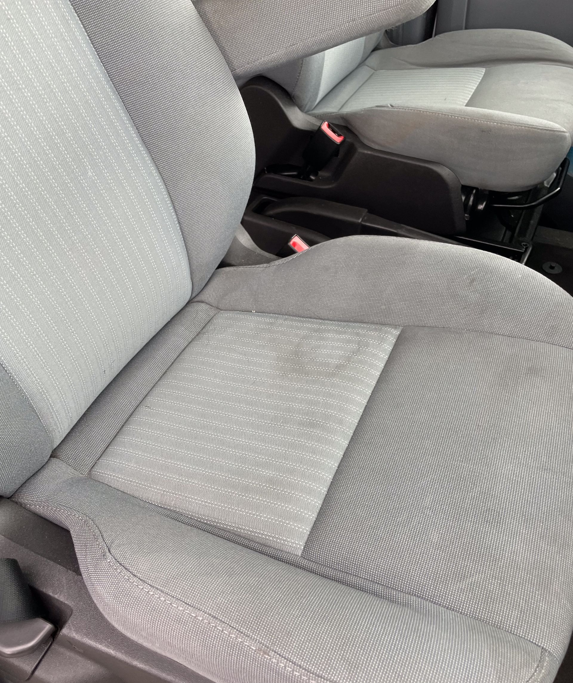 Gray fabric car seats. One seat is in focus. Another seat is visible in the background.