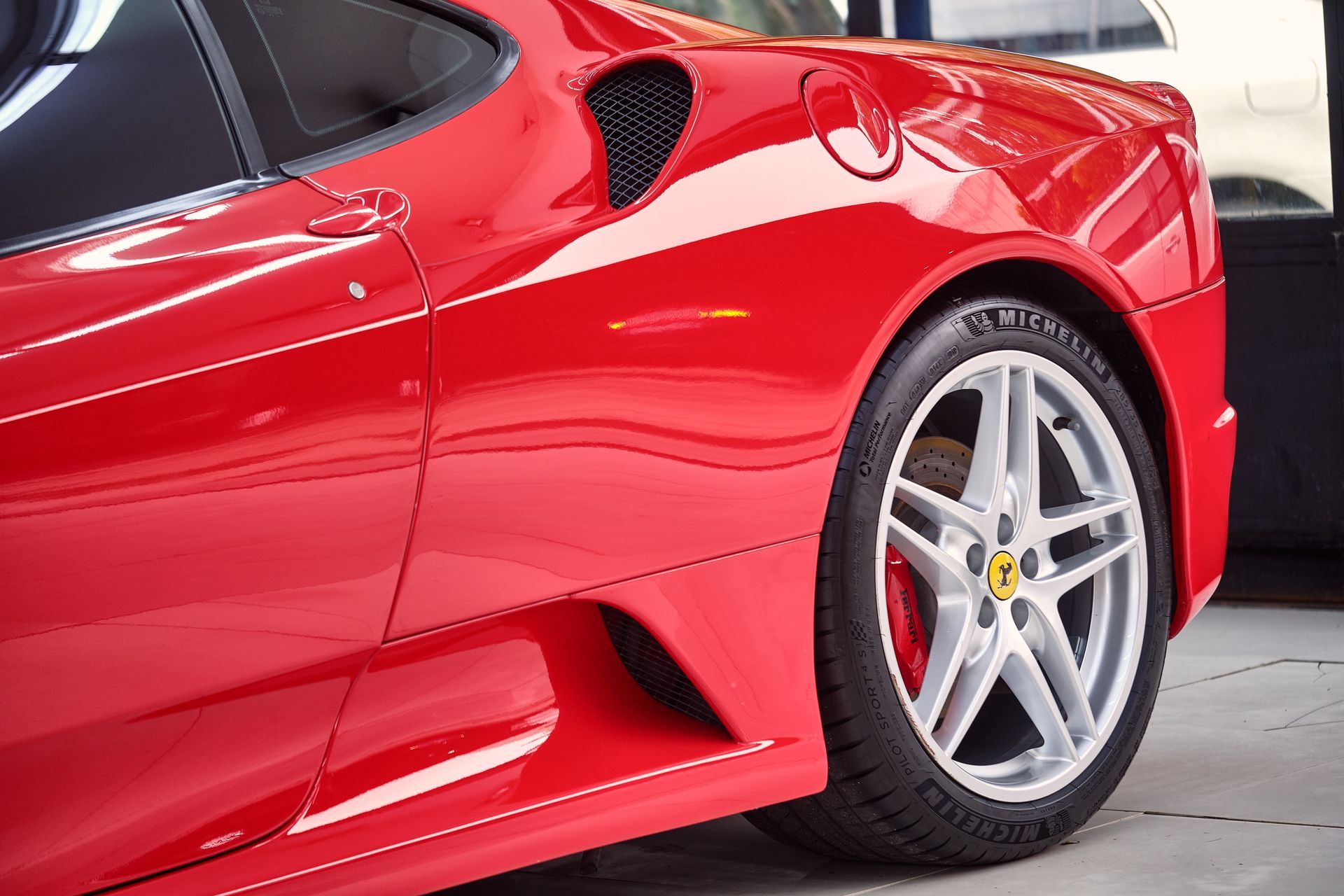 Red Ferrari sports car with silver wheels.