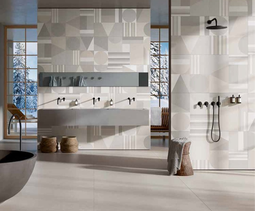 Bagno moderno con piastrelle a motivi geometrici, un ampio mobile lavabo con più lavandini e vista su un paesaggio innevato.