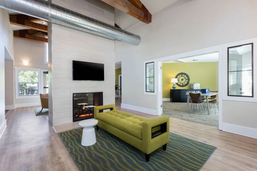 Living room with fireplace, TV, green bench, and open doorway to dining area.