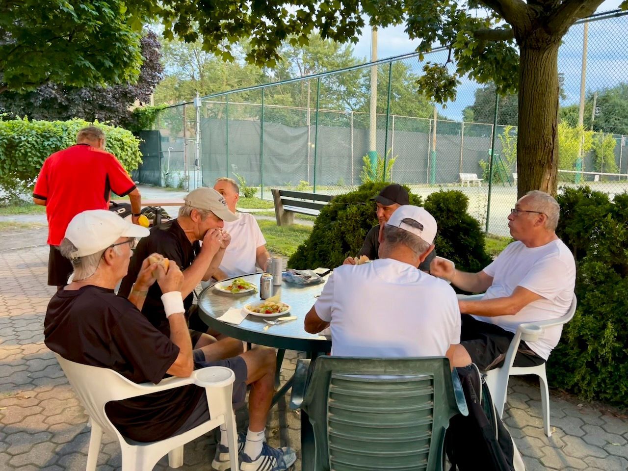 A group of men are sitting around a table eating food