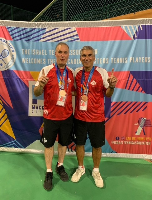 A man wearing a blue shirt and black gloves is smiling