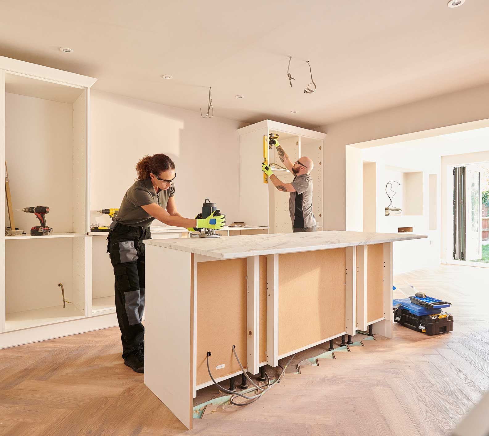 A man and a woman are working on a kitchen island.