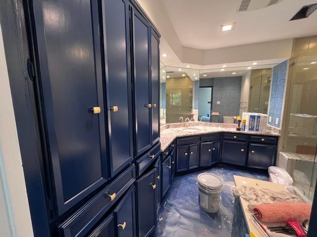 A bathroom with blue cabinets and a toilet.