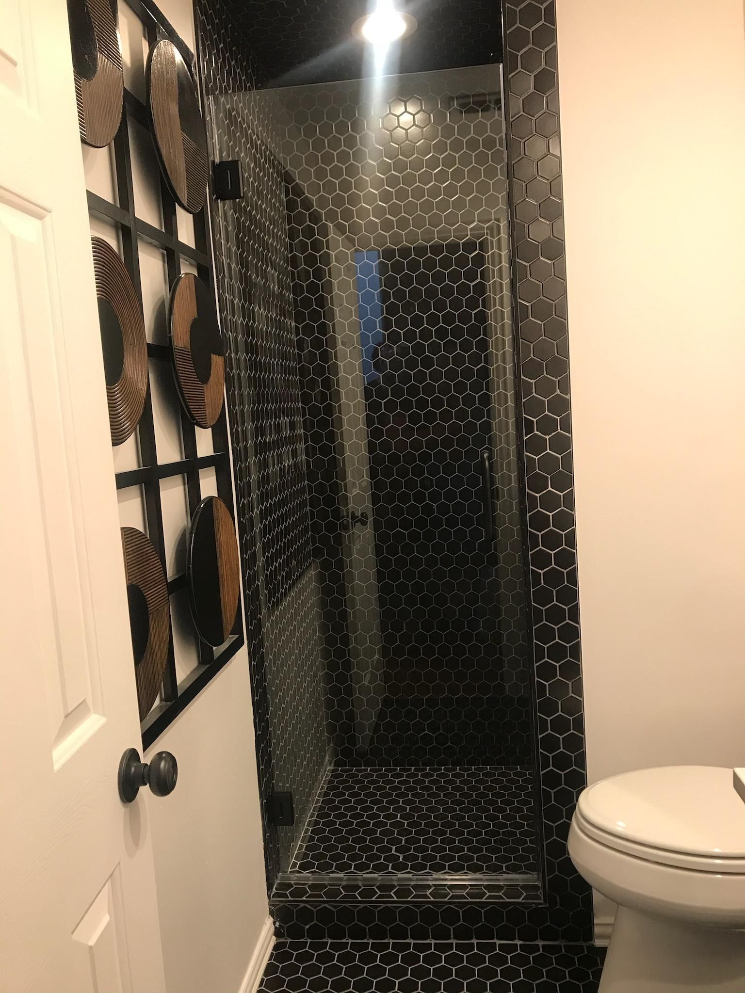 A bathroom with a toilet and a walk in shower.