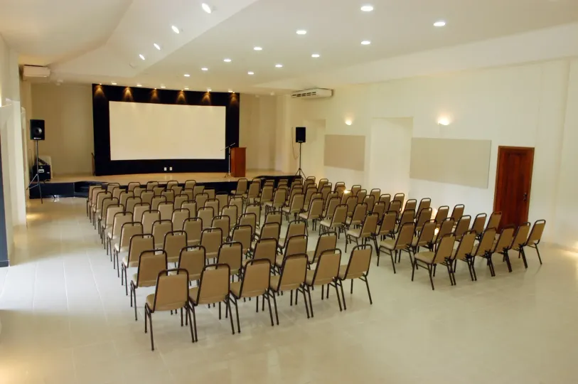 Uma sala grande com fileiras de cadeiras e uma tela grande  -HOTEL-FAZENDA-PARAISO
