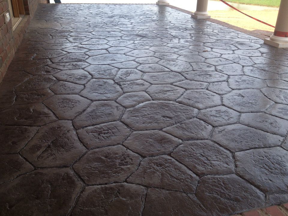 Stamped concrete patio with large, irregular stone pattern; dark gray color.