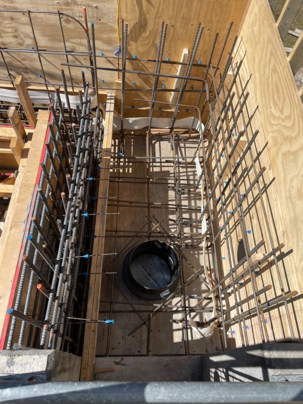 Reinforced steel bars within wooden formwork, prepared for concrete pouring in a construction site.