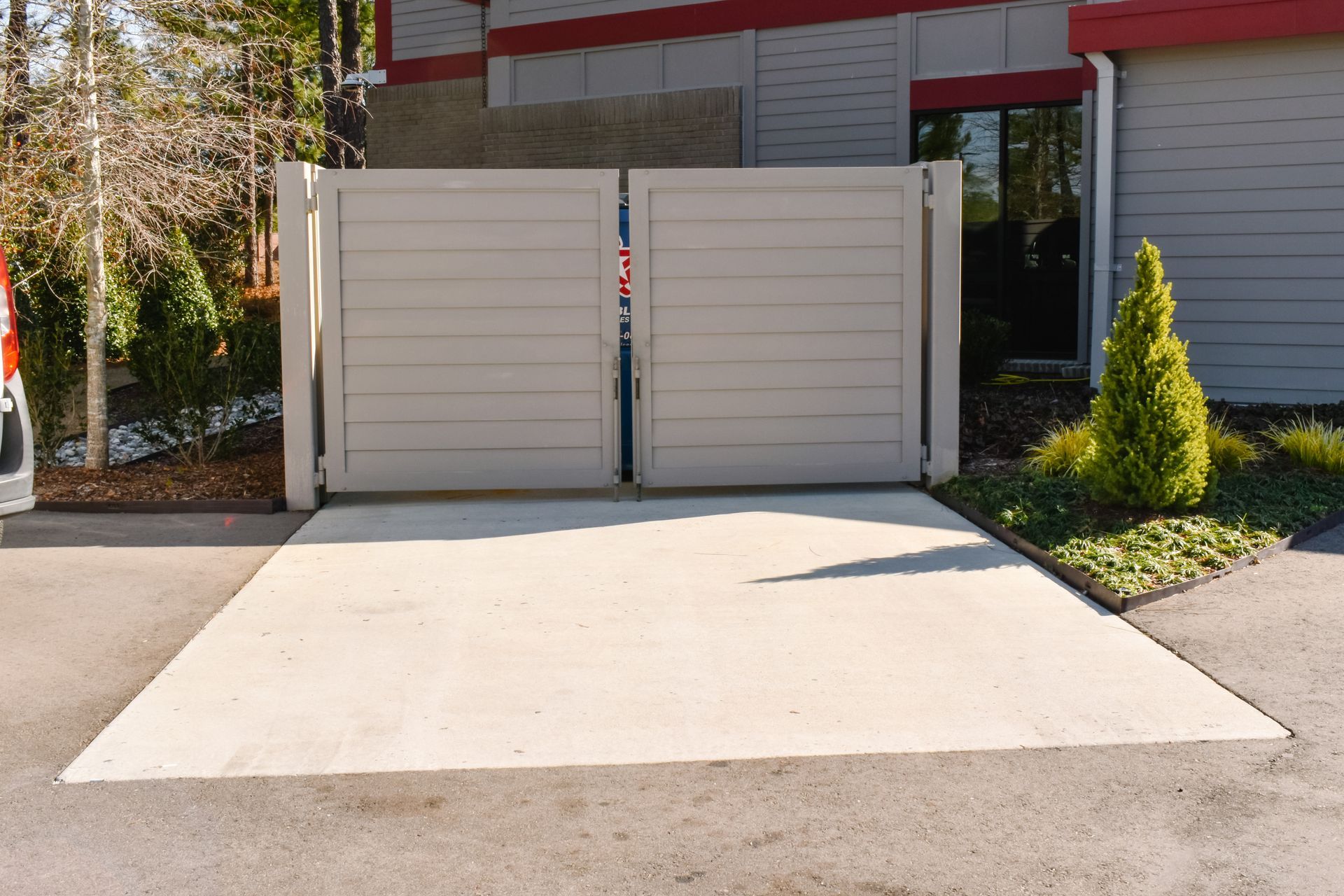 Reinforced steel rebar grid within wooden forms, ready for concrete pour, outdoors next to a concrete wall.