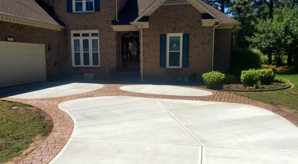 House under construction with a concrete ramp for accessibility. Tyvek wrap visible, worker on roof. House under construction with a concrete ramp for accessibility. Tyvek wrap visible, worker on roof.