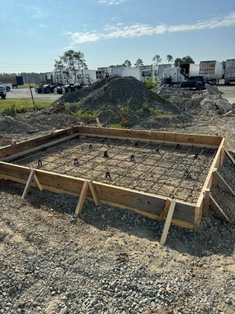 Concrete foundation framework with rebar, ready for pouring. Wooden frame with rebar, ready for concrete pouring, outdoors.